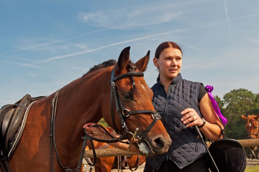 woman preparing her horse for an upcoming horse show 